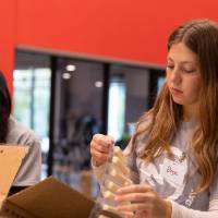 Two students loading packaged string cheese into a box